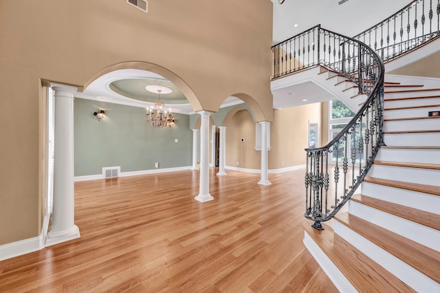1062 Center Ridge Rd, Collierville, TN 38017 - foyer with ornate columns, a high ceiling, arched walkways, a chandelier, and wood finished floors