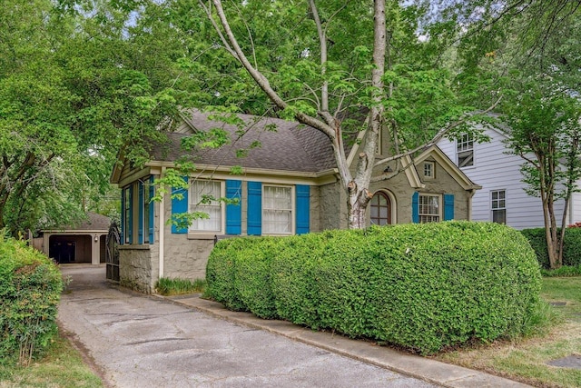 149 Palisade St, Memphis, TN 38111 - view of front of property with an outbuilding, a shingled roof, and stone siding