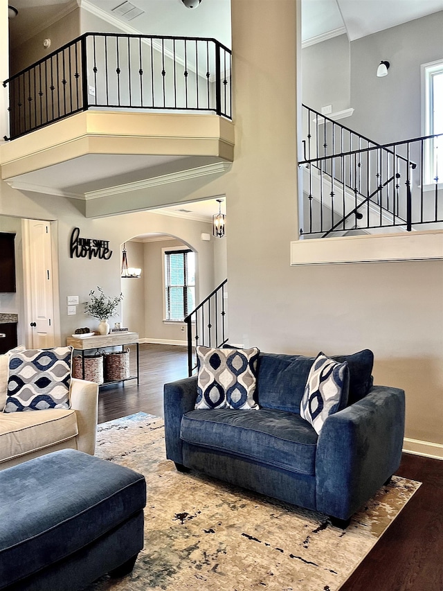 8334 Stonecrest Dr W, Olive Branch, MS 38654 - living room with stairs, crown molding, a high ceiling, arched walkways, and wood finished floors