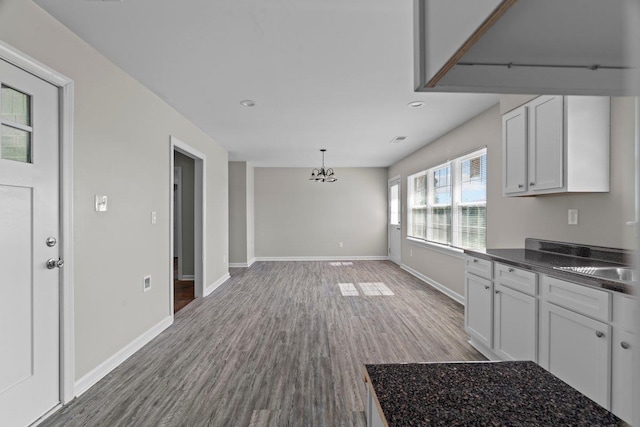 1169 Dovecrest Rd, Memphis, TN 38134 - kitchen featuring dark countertops, wood finished floors, a chandelier, recessed lighting, and white cabinets