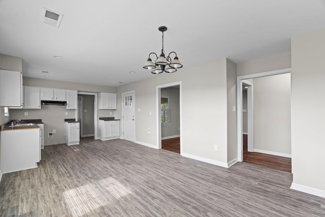 1169 Dovecrest Rd, Memphis, TN 38134 - kitchen featuring white cabinetry, a chandelier, wood finished floors, and under cabinet range hood
