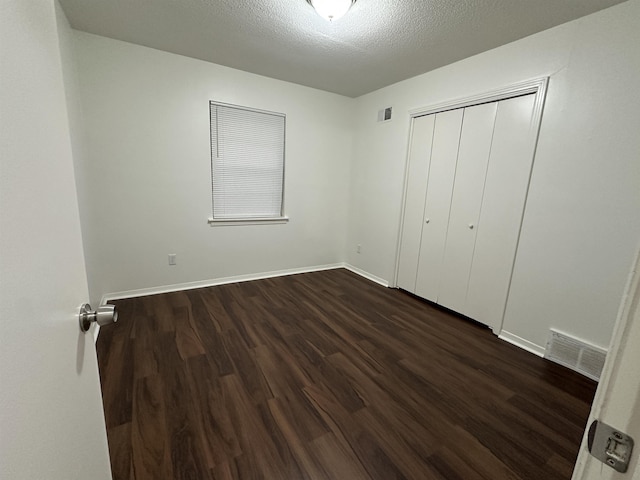 1289 Heathcliff Dr, Memphis, TN 38134 - unfurnished bedroom featuring dark wood finished floors, a closet, and a textured ceiling