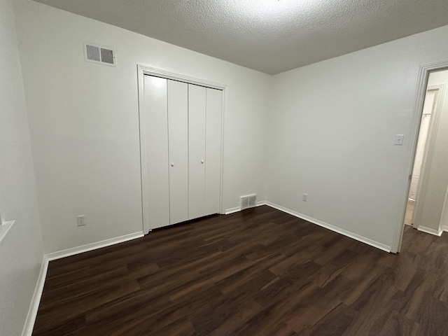 1289 Heathcliff Dr, Memphis, TN 38134 - unfurnished bedroom with dark wood-type flooring, a closet, and a textured ceiling