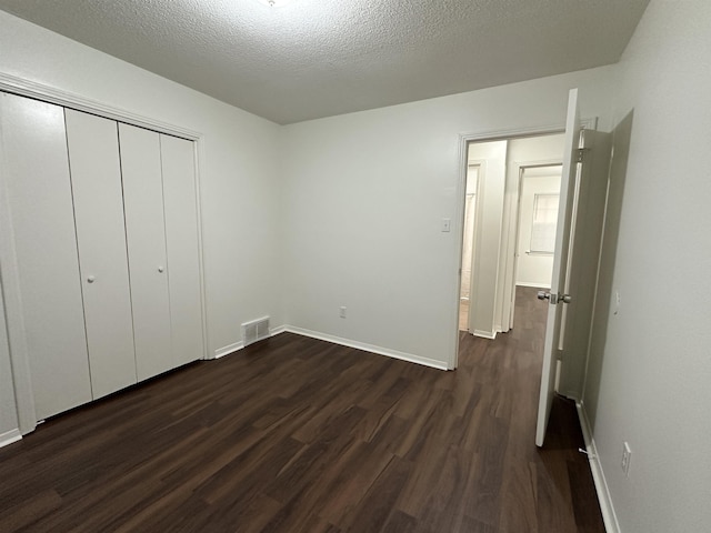 1289 Heathcliff Dr, Memphis, TN 38134 - unfurnished bedroom featuring dark wood-style floors, a closet, and a textured ceiling