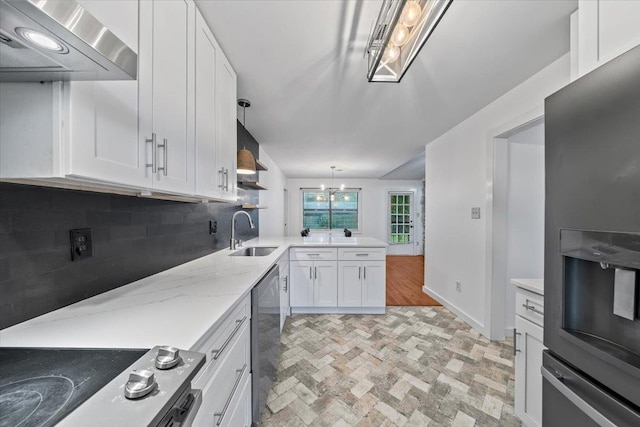 366 Casca Cv, Collierville, TN 38017 - kitchen with appliances with stainless steel finishes, wall chimney range hood, backsplash, white cabinetry, and brick patterned flooring