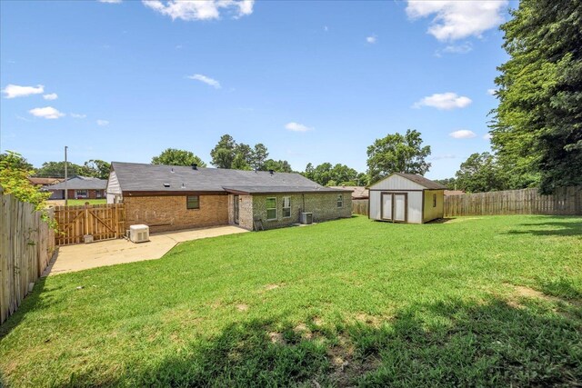 2826 Whitney Ave, Memphis, TN 38127 - rear view of property with a patio, a storage unit, a fenced backyard, and brick siding