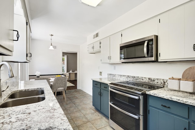 1149 Abbeville St, Collierville, TN 38017 - kitchen featuring appliances with stainless steel finishes, blue cabinetry, hanging light fixtures, and white cabinetry