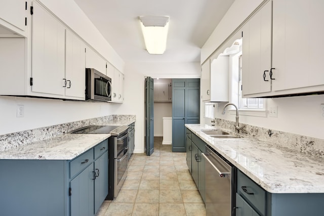 1149 Abbeville St, Collierville, TN 38017 - kitchen with stainless steel appliances, white cabinets, light stone counters, and blue cabinetry