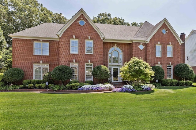 2912 Carnton Dr, Germantown, TN 38138 - colonial house featuring brick siding, roof with shingles, and a front lawn