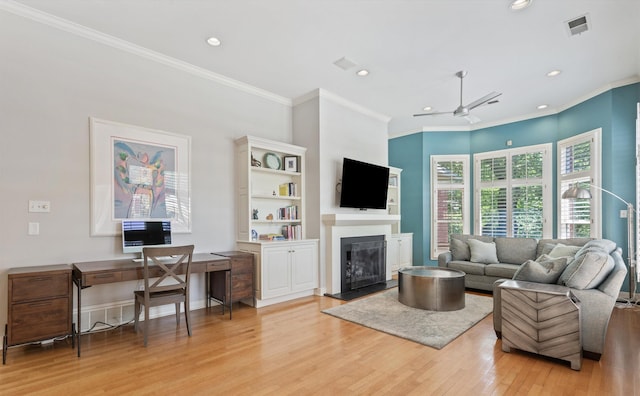 2912 Carnton Dr, Germantown, TN 38138 - living area with light wood finished floors, a glass covered fireplace, crown molding, recessed lighting, and a ceiling fan