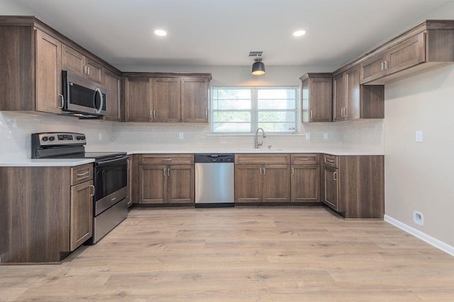 5153 Helene Rd, Memphis, TN 38117 - kitchen with stainless steel appliances, tasteful backsplash, light wood-style flooring, recessed lighting, and light countertops