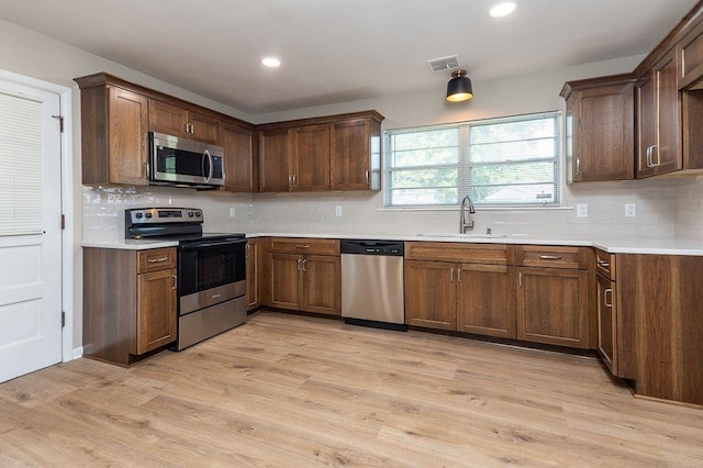 5153 Helene Rd, Memphis, TN 38117 - kitchen with appliances with stainless steel finishes, decorative backsplash, light countertops, light wood-style flooring, and recessed lighting