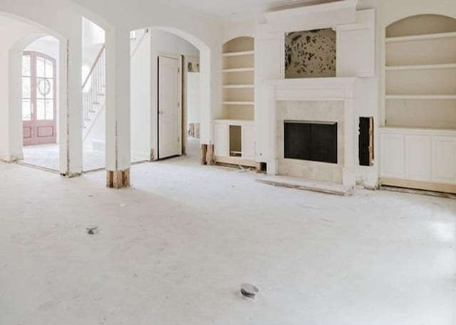 9219 Beaver Valley Ln, Cordova, TN 38018 - unfurnished living room with built in features, stairs, arched walkways, and a high end fireplace