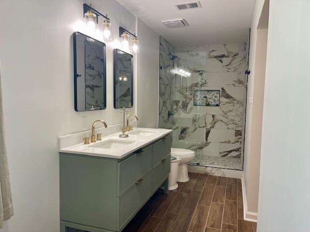 2470 S Flowering Tree Cv, Bartlett, TN 38134 - bathroom with a marble finish shower, double vanity, and wood tiled floors