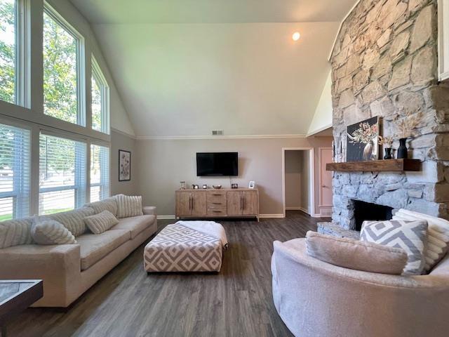 2470 S Flowering Tree Cv, Bartlett, TN 38134 - living area featuring high vaulted ceiling, plenty of natural light, a stone fireplace, and wood finished floors