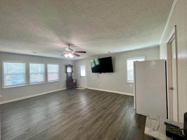 2470 S Flowering Tree Cv, Bartlett, TN 38134 - unfurnished living room featuring dark wood-style floors, a ceiling fan, a textured ceiling, and plenty of natural light