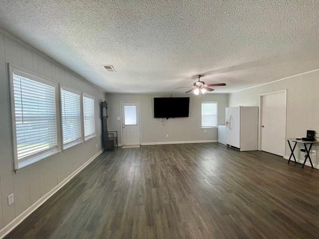 2470 S Flowering Tree Cv, Bartlett, TN 38134 - unfurnished living room featuring dark wood-style floors, ceiling fan, and a textured ceiling