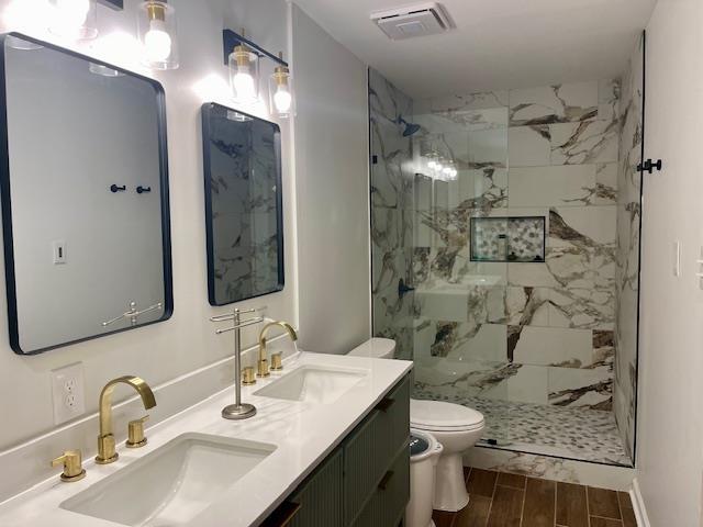 2470 S Flowering Tree Cv, Bartlett, TN 38134 - bathroom featuring a marble finish shower, wood finish floors, and double vanity