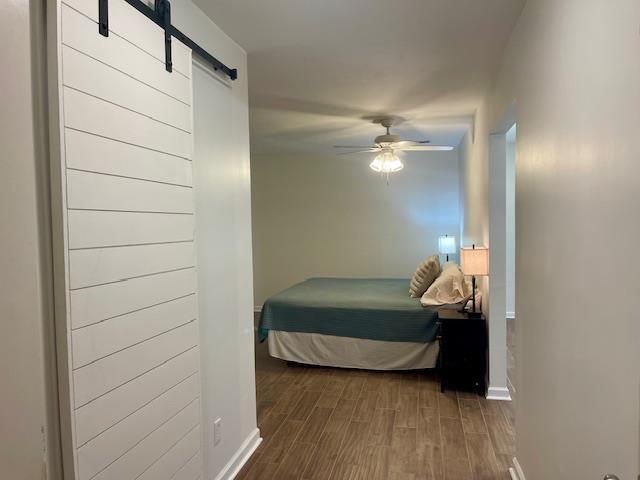 2470 S Flowering Tree Cv, Bartlett, TN 38134 - bedroom with a barn door, wood finished floors, and a ceiling fan
