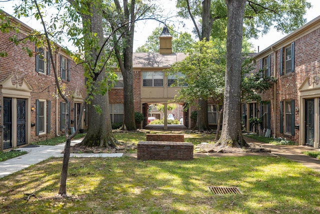 1204 Chamberlain Dr Unit 10, Memphis, TN 38119 - view of front facade featuring a front lawn, brick siding, and a chimney