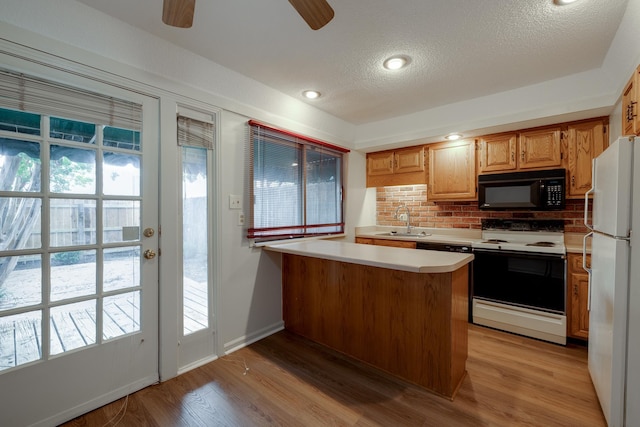 1204 Chamberlain Dr Unit 10, Memphis, TN 38119 - kitchen with white appliances, backsplash, a peninsula, a textured ceiling, and light wood finished floors