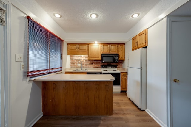 1204 Chamberlain Dr Unit 10, Memphis, TN 38119 - kitchen featuring white appliances, a peninsula, tasteful backsplash, light countertops, and a textured ceiling