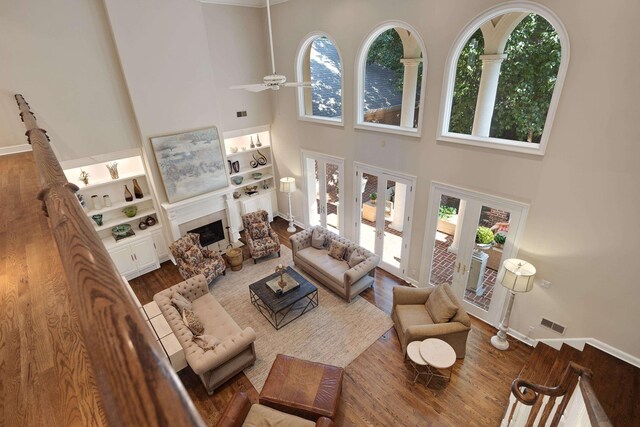 1426 Le Fleur Pl, Memphis, TN 38120 - living room featuring a towering ceiling, healthy amount of natural light, wood finished floors, a fireplace, and a ceiling fan