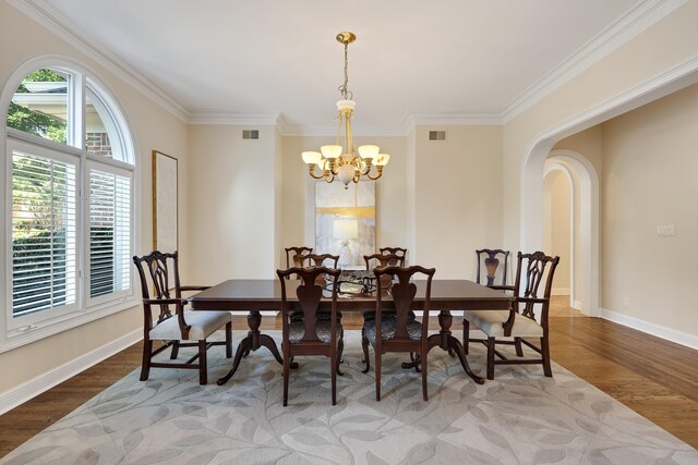 1426 Le Fleur Pl, Memphis, TN 38120 - dining area with wood finished floors, a chandelier, crown molding, and arched walkways