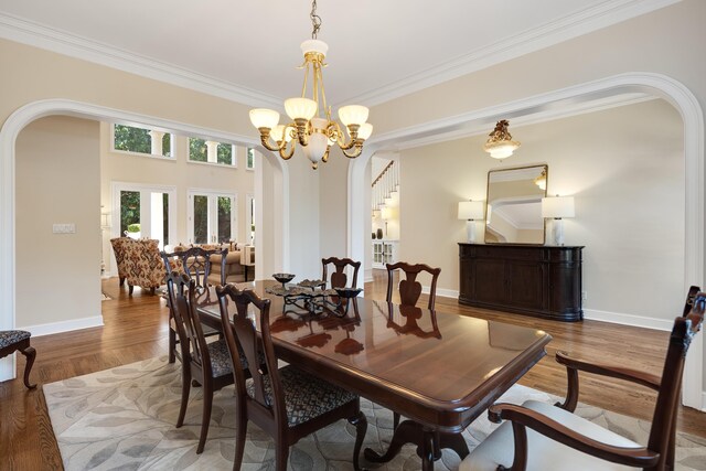 1426 Le Fleur Pl, Memphis, TN 38120 - dining space featuring arched walkways, ornamental molding, wood finished floors, and a chandelier