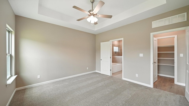 131 Pritchett Cv, Munford, TN 38058 - unfurnished bedroom featuring a spacious closet, carpet, a raised ceiling, and multiple windows
