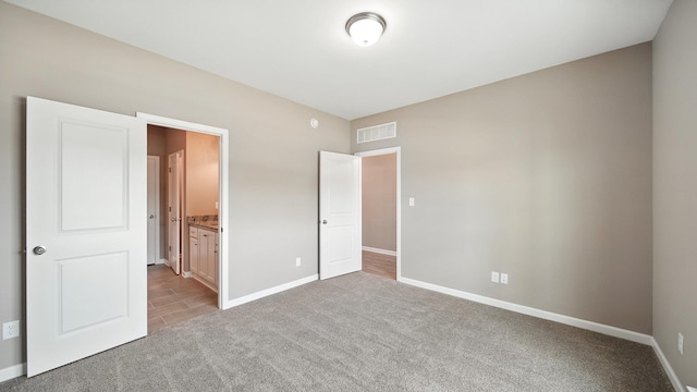 131 Pritchett Cv, Munford, TN 38058 - unfurnished bedroom featuring light carpet, light tile patterned floors, and ensuite bathroom
