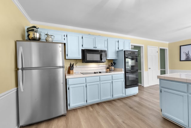 526 Royal Pecan Way, Collierville, TN 38017 - kitchen featuring black appliances, tile counters, crown molding, light wood-type flooring, and blue cabinets