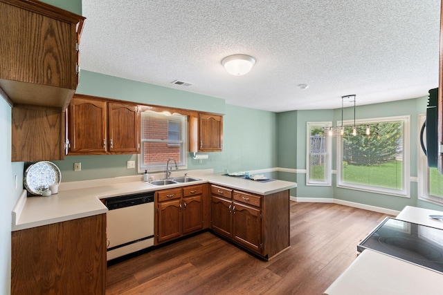 1504 Teal Wing Ln, Memphis, TN 38016 - kitchen featuring white dishwasher, a peninsula, dark wood-style flooring, light countertops, and a textured ceiling