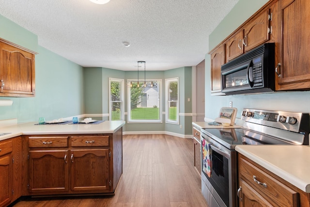 1504 Teal Wing Ln, Memphis, TN 38016 - kitchen with electric range, black microwave, a peninsula, wood finished floors, and light countertops