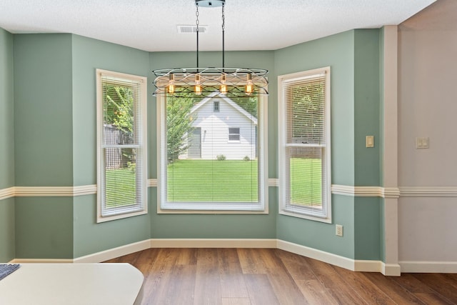 1504 Teal Wing Ln, Memphis, TN 38016 - unfurnished dining area featuring a chandelier, wood finished floors, and a textured ceiling