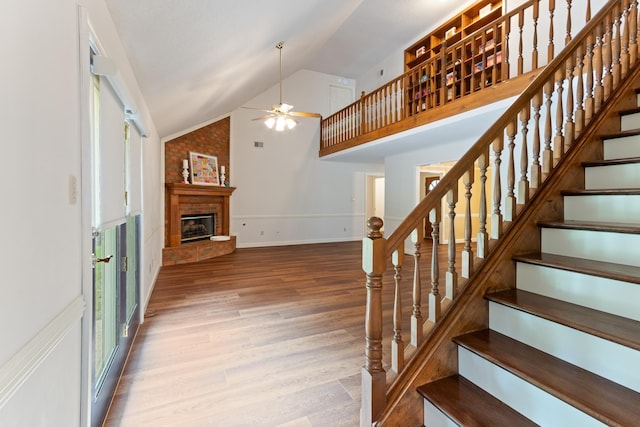 1504 Teal Wing Ln, Memphis, TN 38016 - staircase with ceiling fan, wood finished floors, a brick fireplace, and high vaulted ceiling
