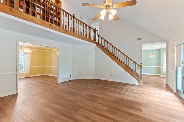 1504 Teal Wing Ln, Memphis, TN 38016 - unfurnished living room with wood finished floors, stairway, high vaulted ceiling, and a ceiling fan