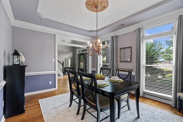 1775 Lisson Cv, Collierville, TN 38017 - dining room with a tray ceiling, a chandelier, crown molding, stairs, and wood finished floors