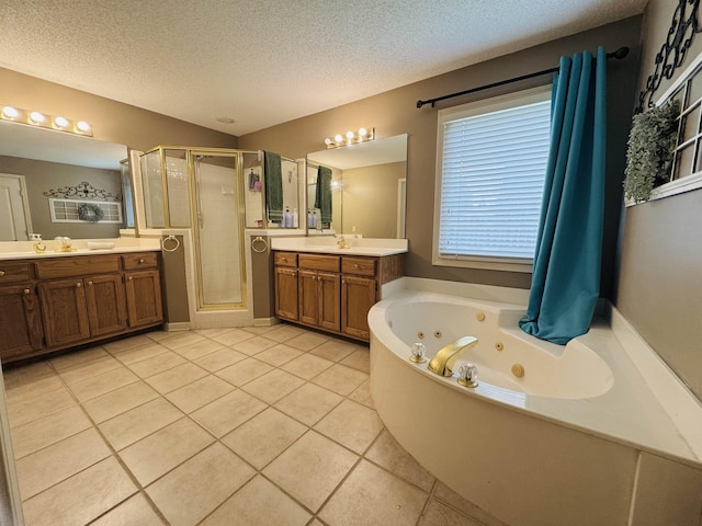 902 Wildbird Cv, Collierville, TN 38017 - bathroom featuring tile patterned floors, a stall shower, a textured ceiling, a jetted tub, and two vanities