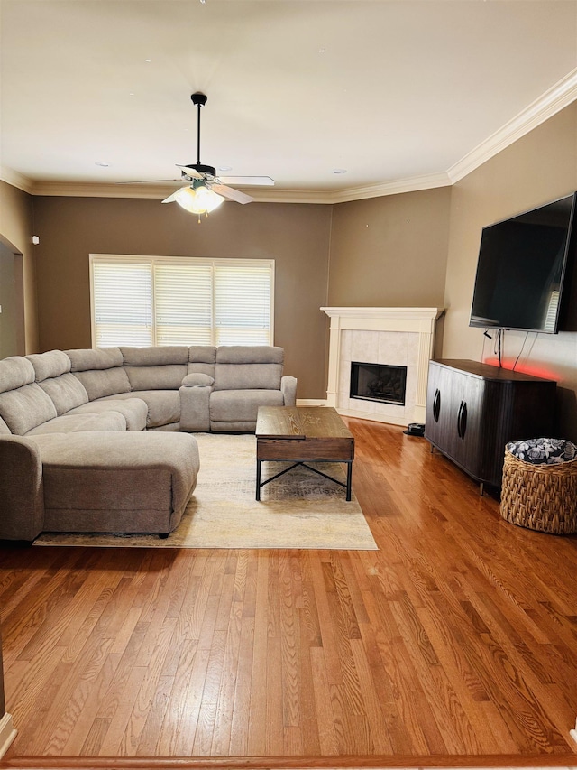 902 Wildbird Cv, Collierville, TN 38017 - living area with a ceiling fan, wood finished floors, a tiled fireplace, and crown molding