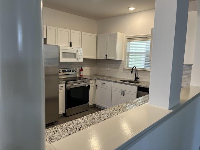 1319 E Island Pl E, Memphis, TN 38103 - kitchen with stainless steel appliances, white cabinets, and backsplash