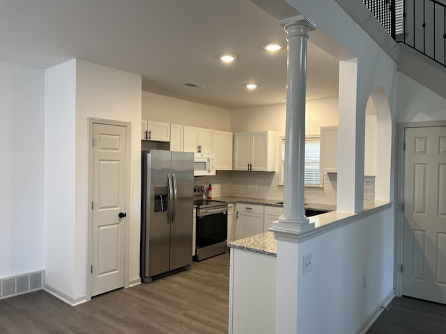 1319 E Island Pl E, Memphis, TN 38103 - kitchen featuring stainless steel appliances, ornate columns, wood finished floors, and recessed lighting