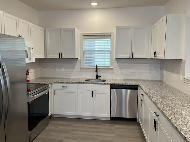 1319 E Island Pl E, Memphis, TN 38103 - kitchen with stainless steel appliances, light stone countertops, recessed lighting, wood finished floors, and decorative backsplash