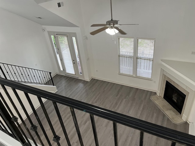 1319 E Island Pl E, Memphis, TN 38103 - unfurnished living room featuring wood finished floors, ceiling fan, a tiled fireplace, and stairway