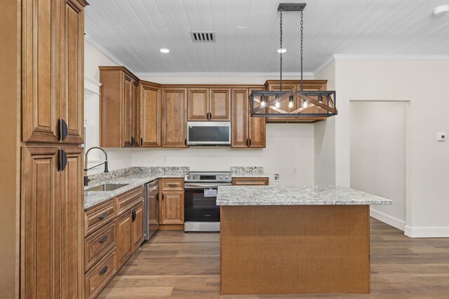 4454 County Road 200th Rd, Corinth, MS 38834 - kitchen featuring appliances with stainless steel finishes, ornamental molding, brown cabinets, light stone countertops, and a center island