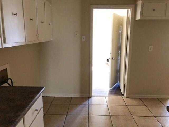 3907 Bowmar Cv, Memphis, TN 38128 - laundry area with cabinet space, washer hookup, and light tile patterned flooring