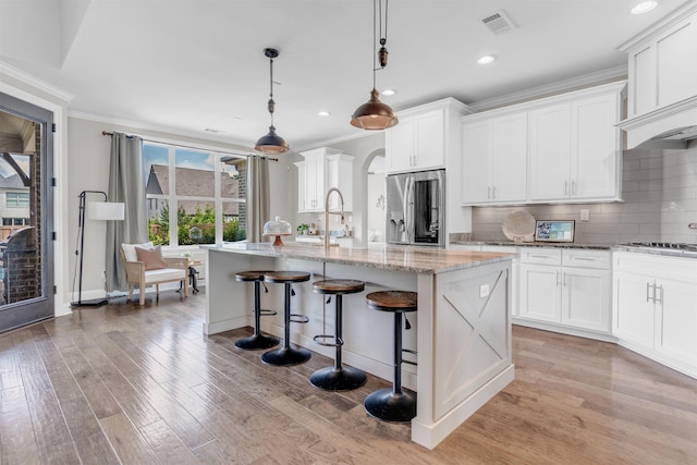4712 Carousel Ln, Collierville, TN 38017 - kitchen with stainless steel refrigerator with ice dispenser, crown molding, a center island with sink, backsplash, and light stone countertops