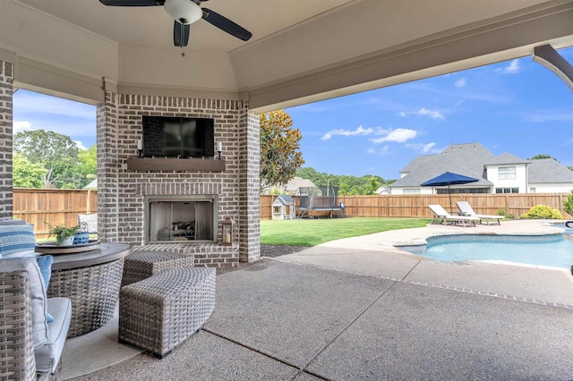 4712 Carousel Ln, Collierville, TN 38017 - fenced backyard with an outdoor brick fireplace, a patio, a ceiling fan, and a trampoline