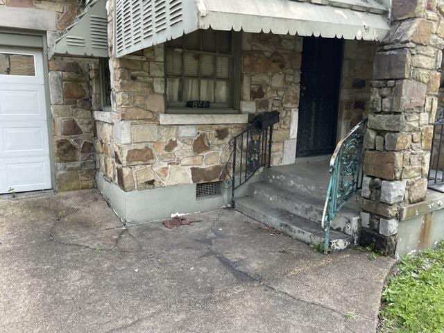 827 E Mallory Ave E, Memphis, TN 38106 - view of exterior entry featuring stone siding and a garage