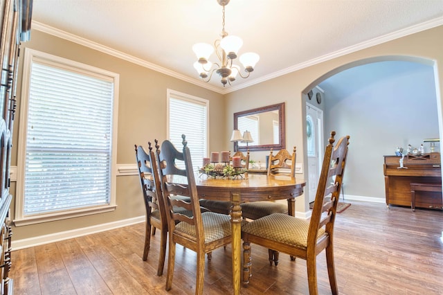 4362 Bridgestone Cir, Bartlett, TN 38135 - dining area featuring arched walkways, a chandelier, wood finished floors, ornamental molding, and plenty of natural light